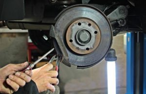 an expert fixing the brake of a car